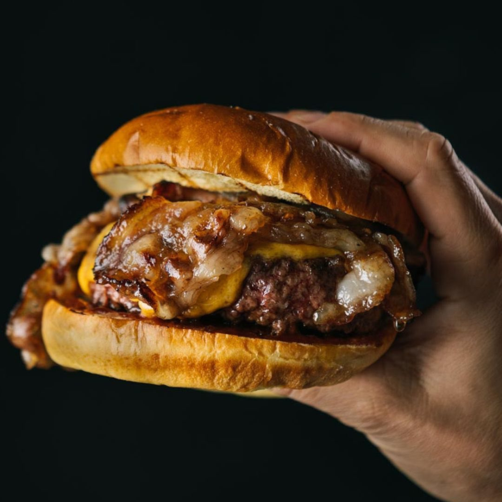 Hamburguesa La Jugosa con queso y cebolla caramelizada